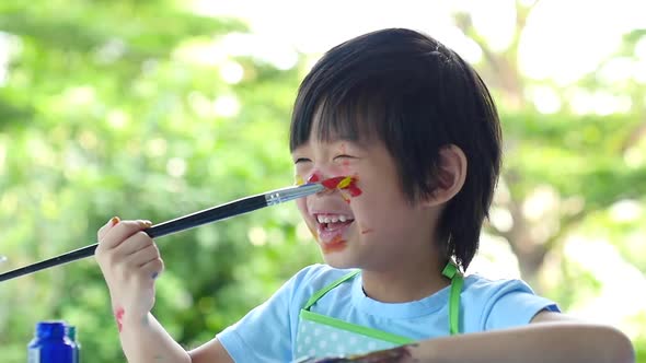 Close Up Of Asian Child Painting On His Face alt