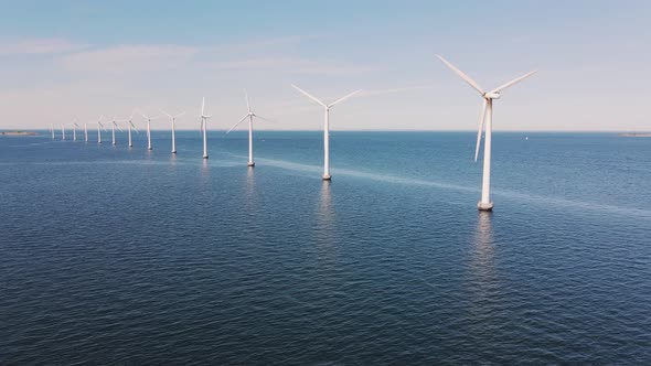 Drone Flies Towards an Offshore Windmill Row in the Ocean