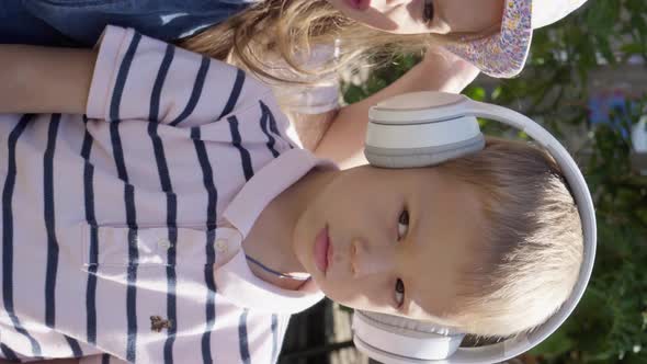 Vertical Cute Little Three Children With Headphones Listening to Music