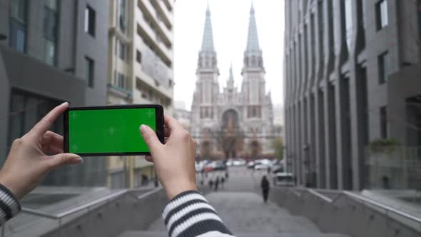Girl Uses a Phone with a Green Screen on a Street of Milan