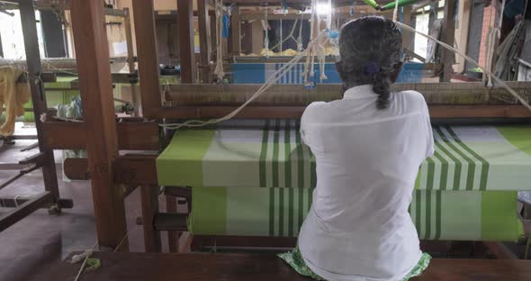 A Footage of a Woman Using Loom in a Traditional Asaian Factory