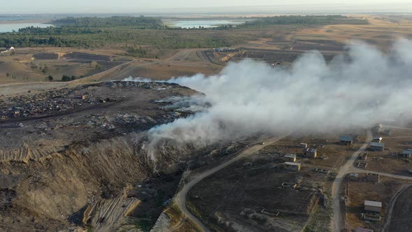 Aerial view of burning garbage pile in trash dump or landfill alt