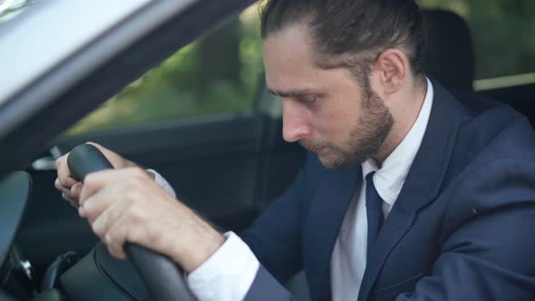 Hopeless Handsome Young Man Leaning on Steering Wheel in Car Crying Out Loud alt