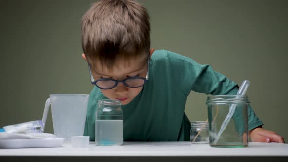 Boy in Glasses Does Chemical Experiment with Pipette and Liquid Indoor. Studying, Learning with