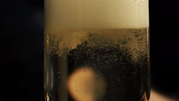 Pouring sizzling bubbly champagne into a glass releasing fermentation and carbonization - Close up s alt