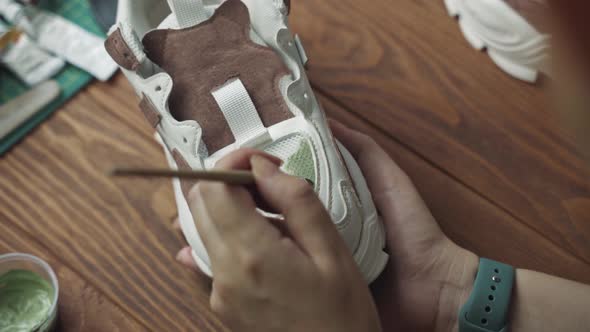 Artist Applies Green Acrylic Paint on White Sneaker with Brush