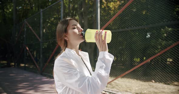 Female Athlete Relaxing After Workout in the Park alt