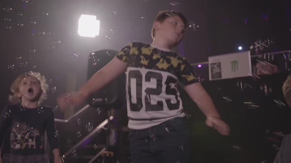 Young Boy Dancing at Party Whilst Bubbles are Blown All Around Him - Ungraded alt