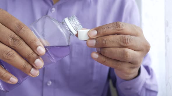 Mouthwash Liquid Flowing Into a Cap alt