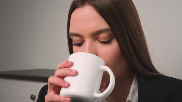 Portrait of Satisfied Businesswoman Drinking Tea at Home Office alt