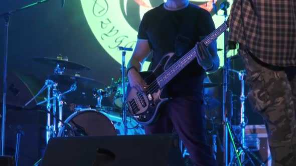 Bass Guitarist at a Rock Concert Plays Guitar on Open Stage. Slow Motion alt
