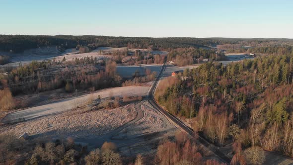 Rural Road in Frozen Landscape Forest Aerial Forward