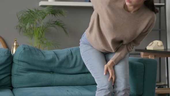 Woman Having Back Pain on Sofa alt