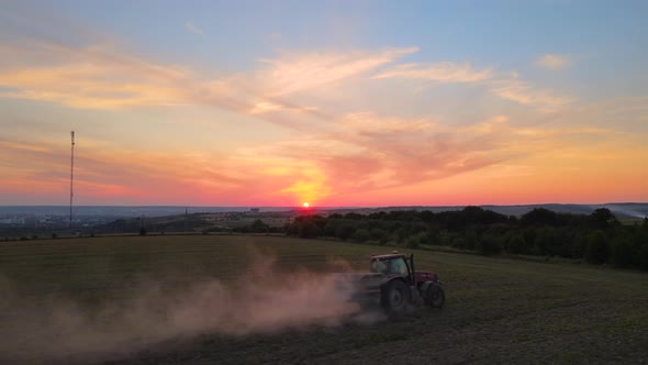 Tractor Spraying Fertilizers with Insecticide Herbicide Chemicals on Agricultural Field at Sunset alt