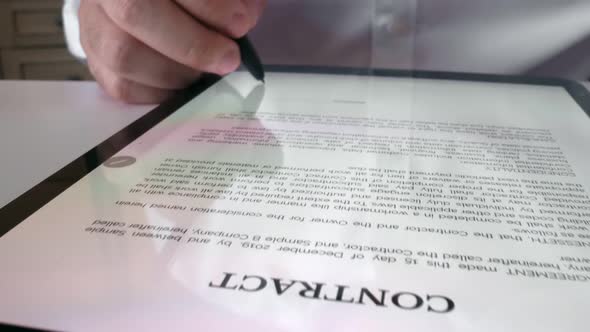 Man sign signature on digital contract at tablet computer in close up view. alt