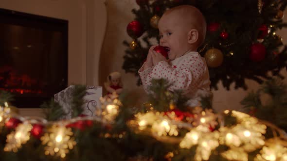 Little Child Waiting for Christmas Sits By the Christmas Tree