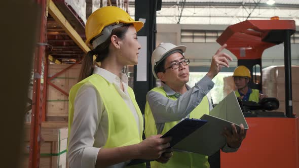 Asian factory manager and engineer woman working in warehouse