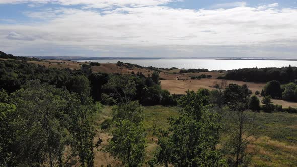 Aerial view of the coastline of Sejerøbugten with hills, fields and ocean. alt