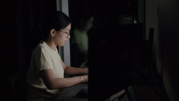 Asian woman freelance wearing glasses typing keyboard on computer.