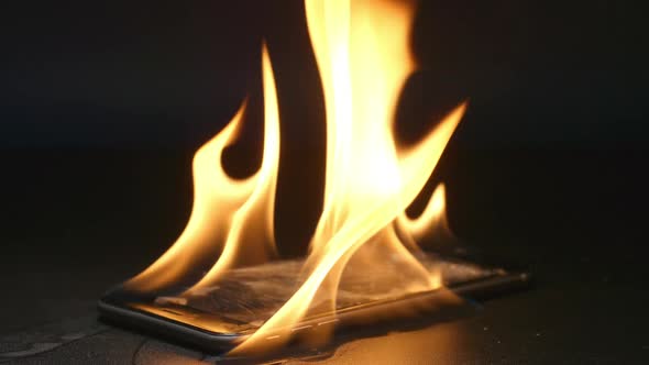 Smashed smartphone is burning on a table