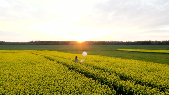 Woman Walking In Yellow Meadow During Sunset