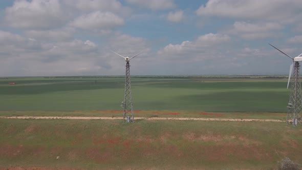 Aerial view of wind turbines energy production and road on fields. 4k shot footage