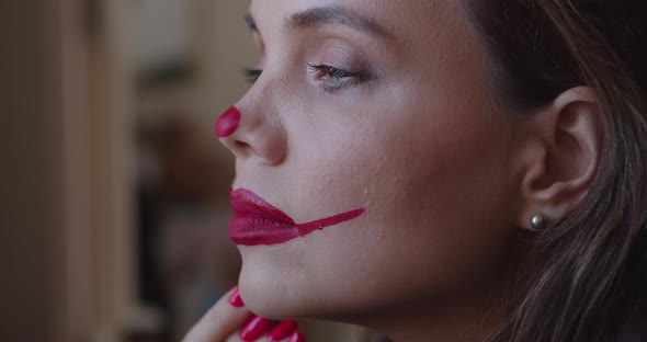 Young Woman Paints Clown Makeup on Her Face