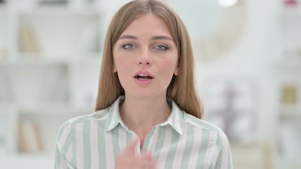 Portrait of Secretive Young Woman Putting Finger on Lips, Quiet Sign  alt