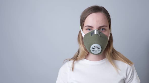 Woman in a Respiratory Mask, Isolated on a Gray Background alt