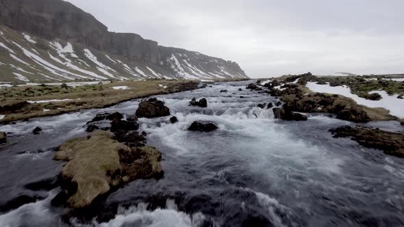 Winter landscape in Iceland with river and waterfall through the countryside alt