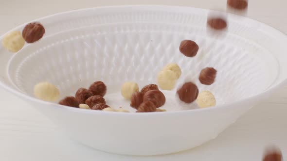 Brown Choco Cereal Balls Falling Into a Bowl Close Up