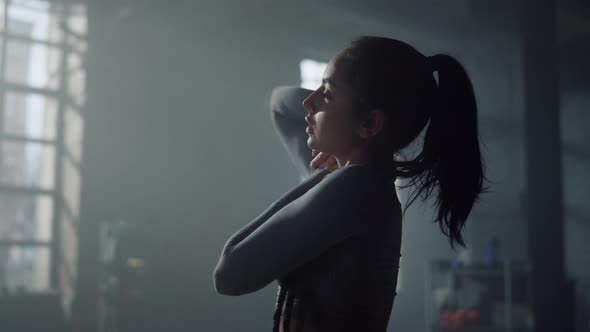 Woman in Sportswear Preparing Body for Exercising alt