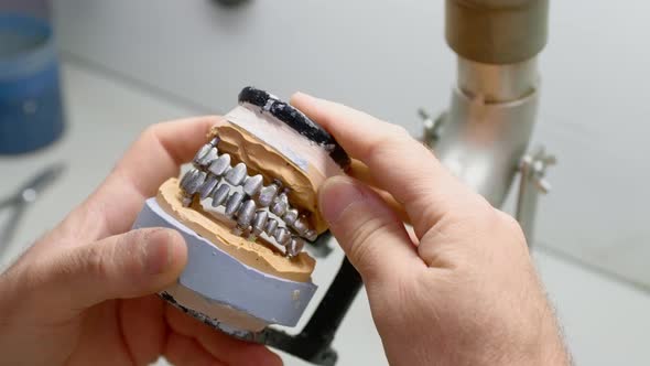 Dental Technician Works in His Workshop and Makes Artificial Teeth for Dentistry alt