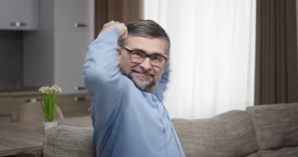 Man Smiling Shows His Strength with His Hands alt