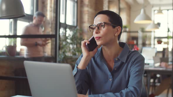 Elegant Businesswoman Talking on Phone in Office alt