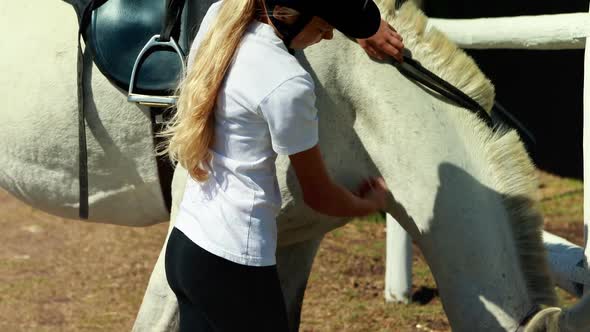 Girl touching the white horse in the ranch 4k alt