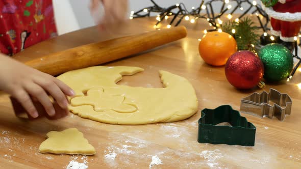 Christmas baking, little girl sculpts festive Christmas gingerbread cookies.