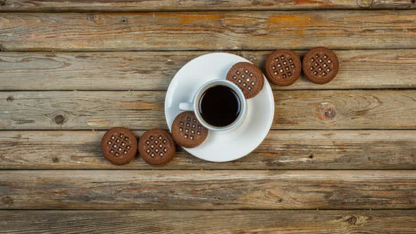 Chocolate Chip Cookies And A Cup Of Coffee Move On A Wooden Surface