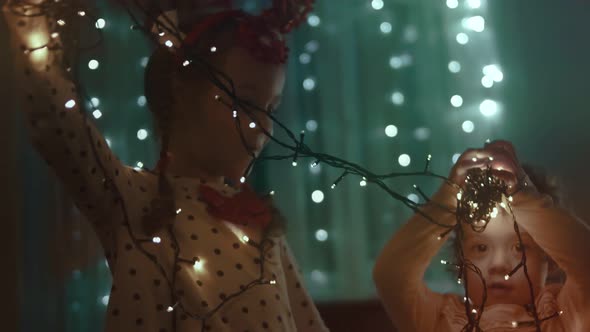 Family Decorating Their Home for Christmas Holidays Beautiful Happy Girls Having Fun Playing with alt