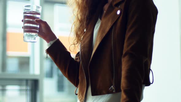 Female executive drinking water at her desk alt
