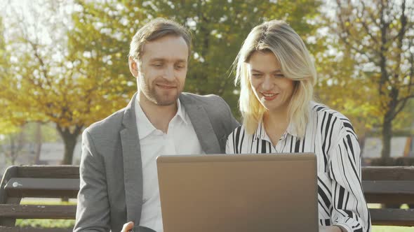Two Business Colleagues Using Laptop at the Park Together alt