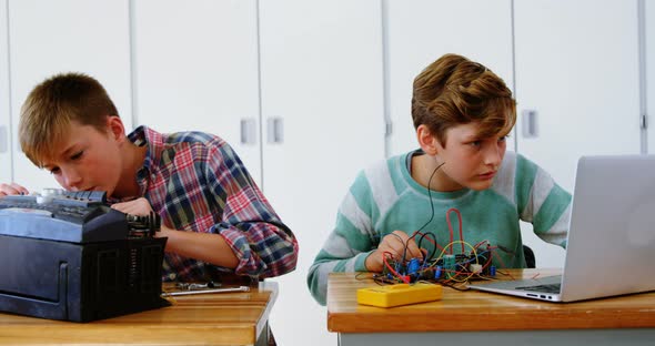 Schoolboys working on electronical project in classroom alt