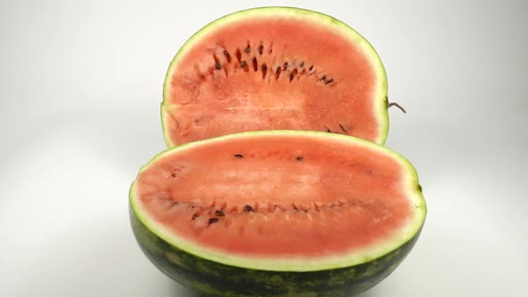 Two halves of a large watermelon, slow motion.