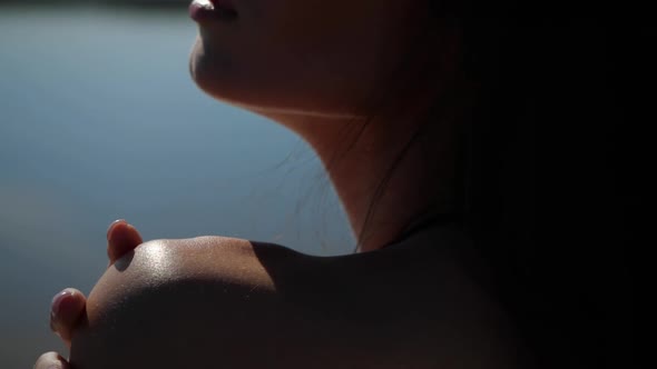 The Sun's Glare Falls on the Woman's Shoulder, Neck, Collarbone