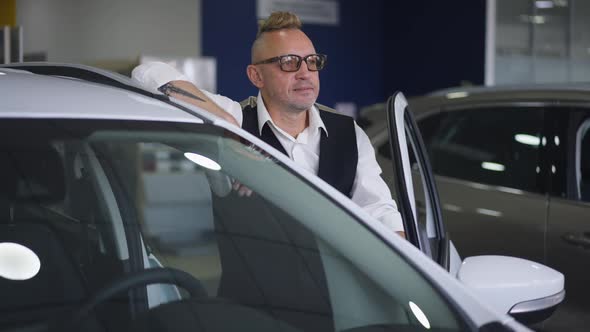 Elegant Adult Caucasian Man with Mohawk Haircut in Eyeglasses Posing at New Luxurious Expensive alt