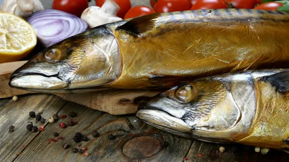 Delicious Smoked Fish Mackerel on a Wooden Table Next to the Cherry Tomatoes Onion alt