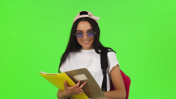 Happy Young Female Student Posing with Her Books and Backpack alt