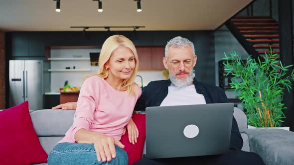 Close Portrait of Mature Man and Woman Browsing the Internet Together alt