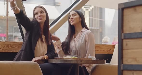 Two Female Friends Posing for Selfie in Restaurant Before Eating Meal Then They Choose the Best