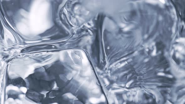 Super Slow Motion Detail Shot of Pouring Alcohol Liquid on Ice Cubes at 1000 Fps alt